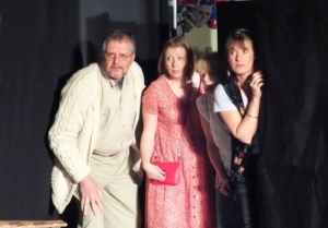A man and three women wait expectantly in the wings